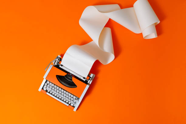 orange 70s typewriter on orange background - typewriter writing journalist typing imagens e fotografias de stock