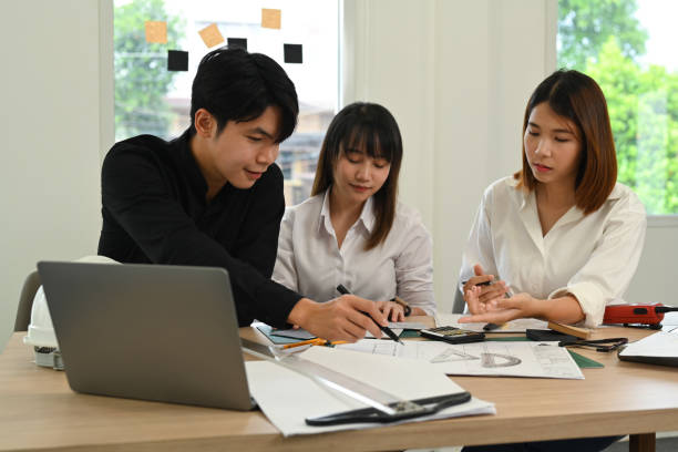 istock Professional team of architects brainstorming, working together on new project and building sketches in modern office. 1433527362