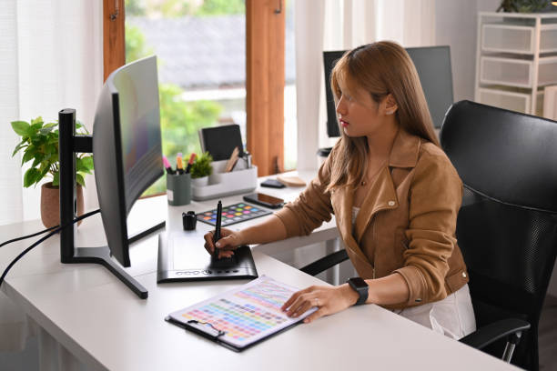istock Asian female freelance graphic designer using digital tablet for making new designs, working at home office. 1433527404