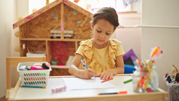 istock Little girl drawing while sitting at the table in her room 1433528968