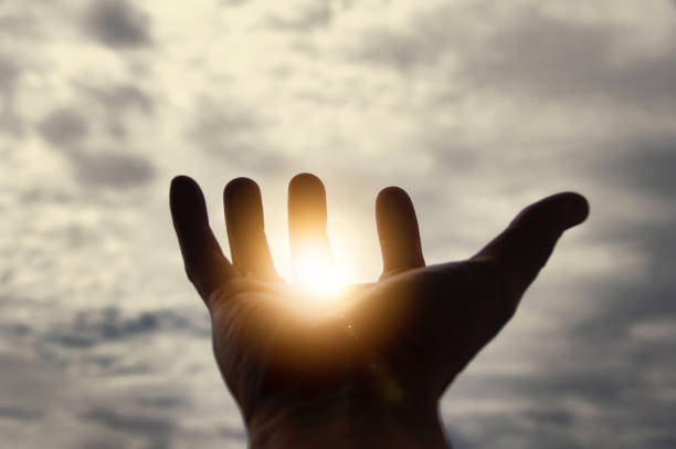 istock Light shining on hand with vintage sky color background. Copy space. 1433529360