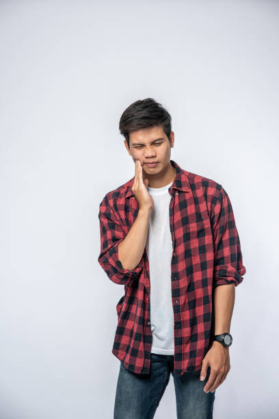 istock A man sick with a toothache and a hand holding on the cheek 1433531572