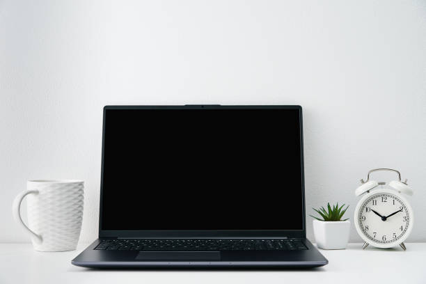 istock Office workplace with laptop, alarm clock and plants on table. Office interior 1433539994