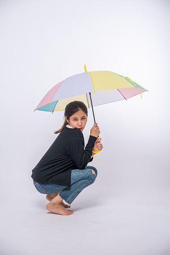 Woman in a black shirt sitting and spreading an umbrella
