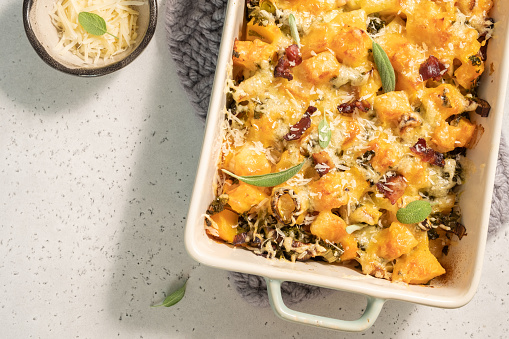 Autumn pumpkin casserole with leek, bacon, cheese and kale