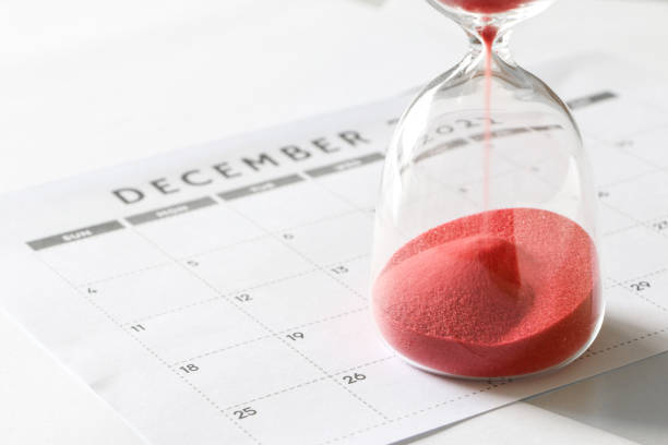 砂時計の球根を駆け抜ける赤い砂、12月のカレンダー、クリスマスと年末へのカウントダウン - deadline time clock urgency ストックフォトと画像