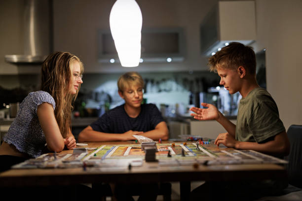 adolescentes jogando grande jogo de tabuleiro juntos em casa - leisure games dice indoors table - fotografias e filmes do acervo
