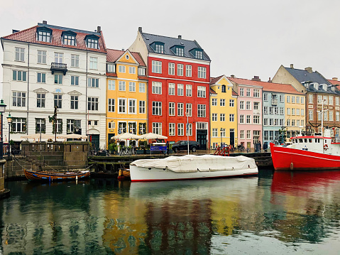Nyhavn district with boats on water canal and colorful row of old houses in Copenhagen, Denmark during the winter