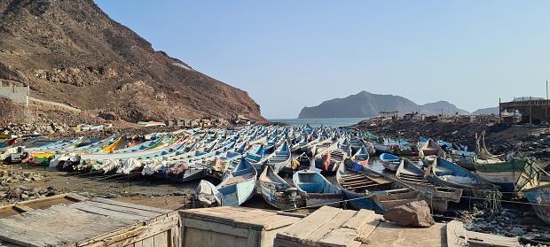 Toma panorámica de una costa superpoblada por barcos de pesca capturados en la bahía de pesca de Adén photo