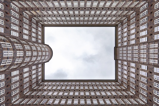 A low angle shot of an urban Sprinkenhof building with glass windows under a blue sky in Hamburg