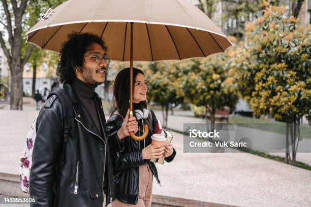 Mixed Race Couple Standing Under Umbrella Stock Photo - Download Image Now - Rain, Umbrella, 20-29 Years
