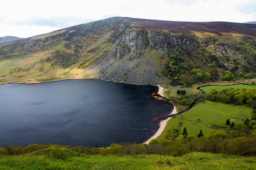 Aerial shot of Wicklow mountains, with a lake and sky background, Ireland