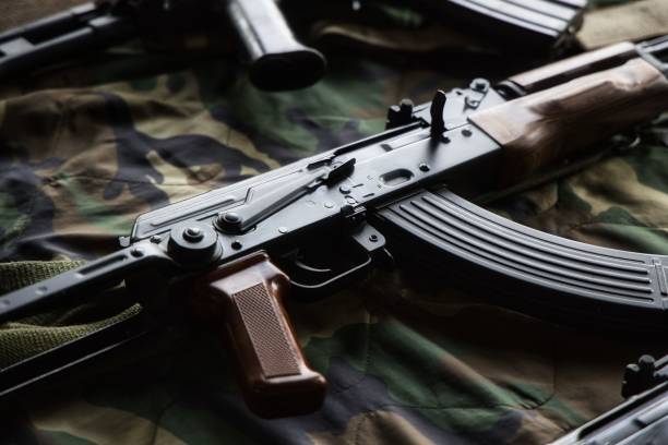 istock Close up of an AK47 firearm on a camouflage pattern fabric 1433560055