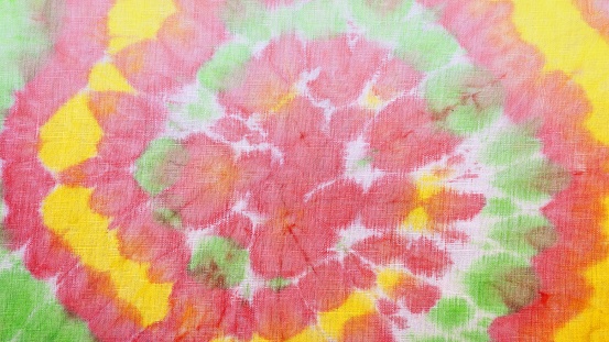 A tie-dye pattern background with colorful staines