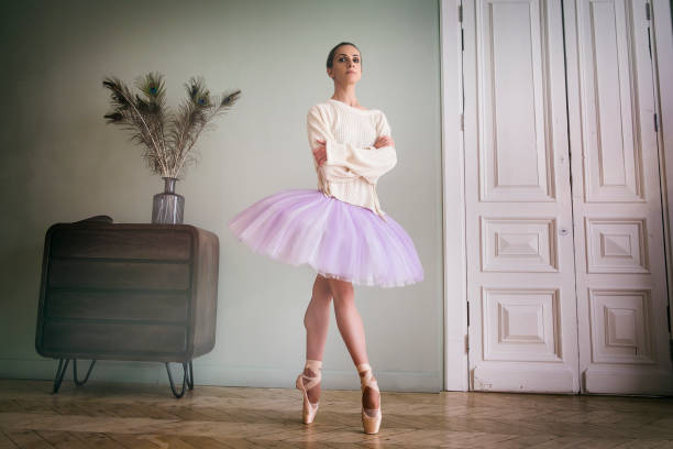 ballerine pose montrant ses jambes dans la pièce devant le miroir en chaussures à pointes et tutu - flying contemporary dancing dancer photos et images de collection