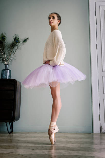 ballerine pose montrant ses jambes dans la pièce devant le miroir en chaussures à pointes et tutu - flying contemporary dancing dancer photos et images de collection