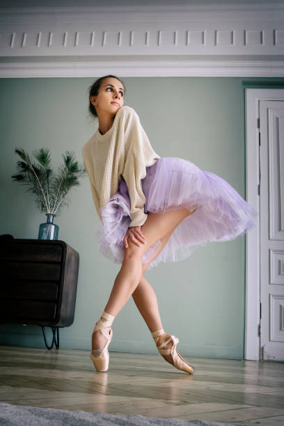 ballerine pose montrant ses jambes dans la pièce devant le miroir en chaussures à pointes et tutu - flying contemporary dancing dancer photos et images de collection