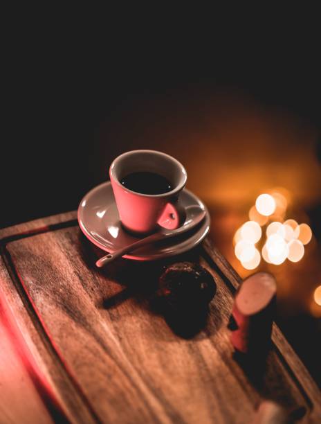 Cup of coffee with spoon on wooden table isolated in bokeh background
