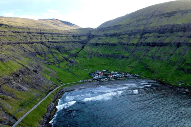 istock Rocky cliffs with green grass at the shore in Faroe Islands 1433563493