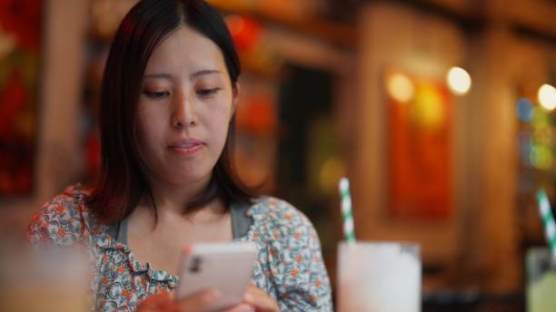 istock Young woman using her phone while relaxing in cafe 1433570787