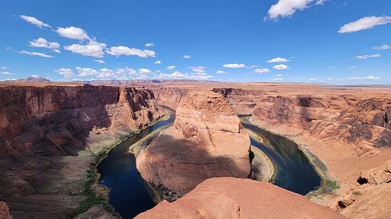 A view of the Horseshoe Bend in Glen Canyon, Arizona, with the Colorado river and the sky in the background.