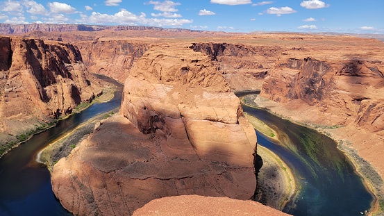 A view of the Horseshoe Bend in Glen Canyon, Arizona, with the Colorado river and the sky in the background.