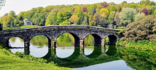 istock Park with an old stone bridge over a river with beautiful trees in the background 1433572582