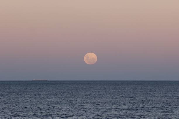 istock Moon over the calm sea at sunset 1433575984