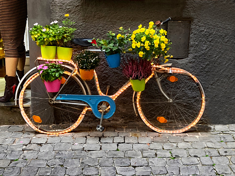 Illuminated Bicycle decorated with Flowerpots in a Street in Castell Gandolfo in Italy