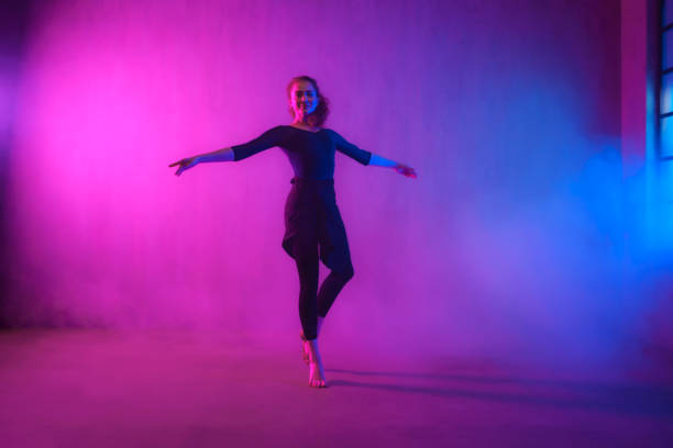 istock Modern dance girl dancer dancing in neon light doing gymnastic exercises in studio, copy space. 1433580273