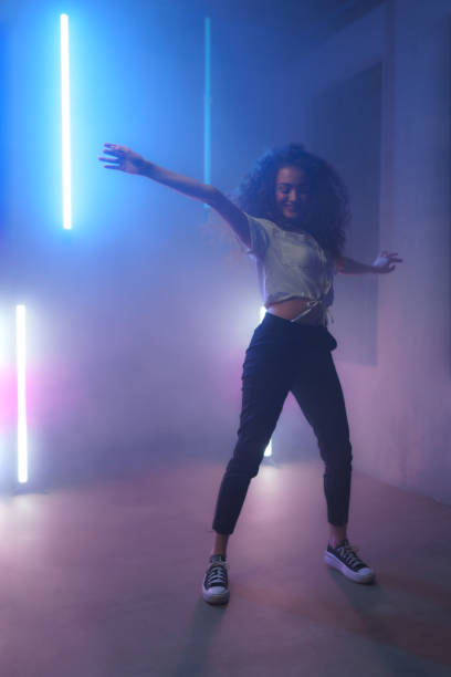 istock Modern dance girl dancer dancing in neon light doing gymnastic exercises in studio, copy space. 1433580432