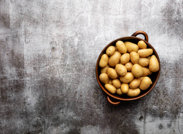 istock Raw small potatoes in a cast iron skillet on a beton background. 1433585653