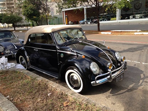 Volkswagen convertible vintage Beetle. Black with beige roof, retro car parked in Sao Paulo, Brazil, August 2022.