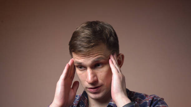 istock Stressed young man massages his head. migraine. close-up. 1433606209