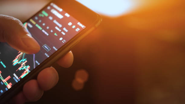 istock Hands with a mobile phone. Crypto trading in smartphone. close-up. Cryptocurrency trading. Sun rays 1433606233