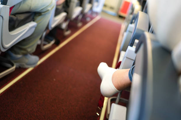 jambes croisées assises dans un avion. - pieds nus photos et images de collection