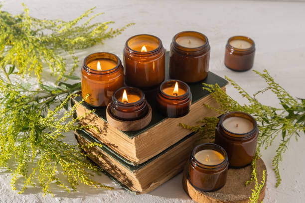 A set of different aroma candles in brown glass jars. Scented handmade candle. Soy candles are burning in a jar. Aromatherapy and relax in spa and home. Still life. Fire in brown jar stock photo