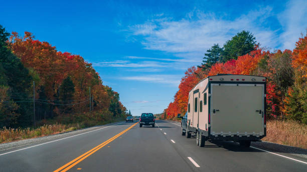 RV Trailer on a Highway going through Autumn Landscape