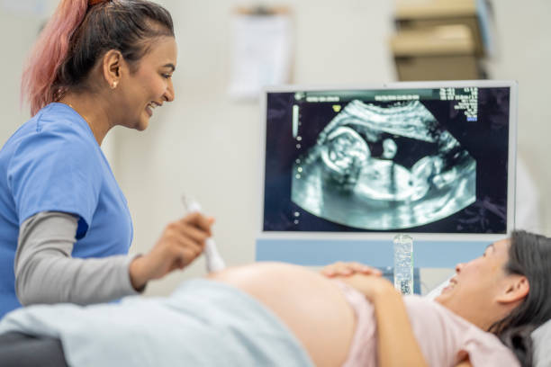 pregnant woman at an ultrasound appointment - ultrasound imagens e fotografias de stock
