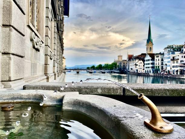 fountain waters stream an endless supply of drinking water in weinplatz public square in the lindenhof quarter, old town, zürich, switzerland. touring zürich, switzerland - may 2022. old town bridge tower stock pictures, royalty-free photos & images