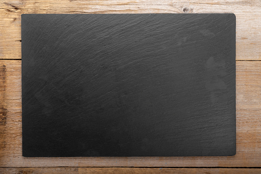 Empty cutting slate board on planks food background concept. Top view.Space for text.