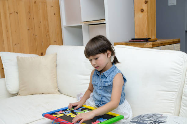 istock Mixed race little girl playing with letters 1433624944