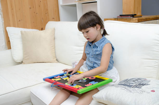 istock Mixed race little girl playing with letters 1433625681