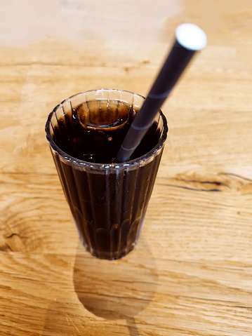 Cold cola drink with ice and straw in glass cup at glasgow scotland england uk