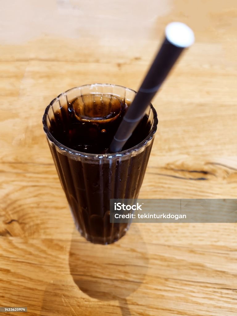 Cold cola drink with ice and straw in glass cup at glasgow scotland england uk Brown Stock Photo
