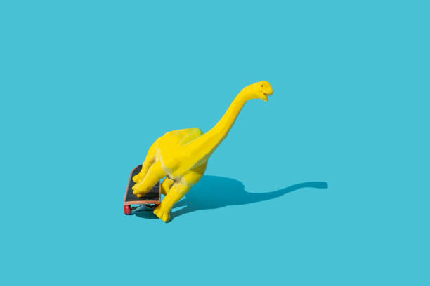 istock Plastic toy dinosaur riding skateboard. Blue background. Minimal design. 1433631000