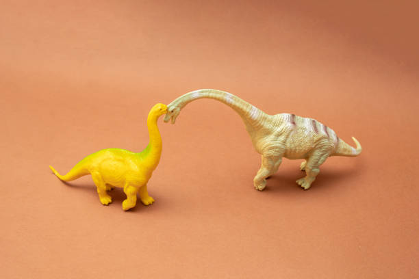 istock Two dinosaurs on a brown background. Plastic toys. Minimal design. 1433631626