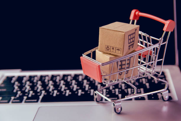 Parcel or Paper cartons in shopping cart on a laptop keyboard. stock photo
