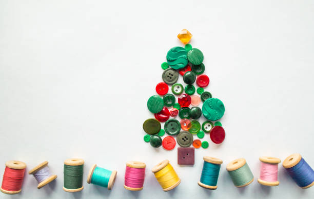 istock Tree made of buttons green, red color. Multicolored threads with wooden spools. White background, copy space. Creative Christmas concept, or gardening 1433638581
