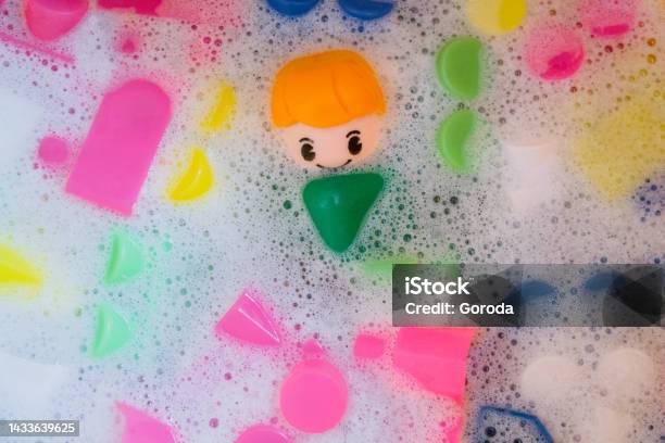 Washing Of Children Toys Plastic Building Blocks With Figurines A Smiling Little Fellow And Colorful Cubes Float In The Foaming Water Stock Photo - Download Image Now
